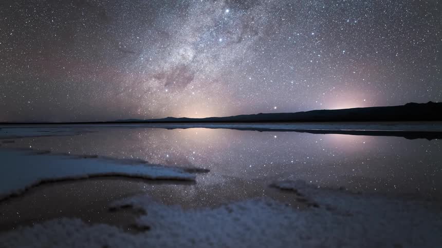 The stars and the milky way reflect on the water