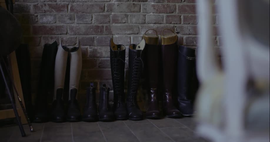 Boots line this brick wall in a home