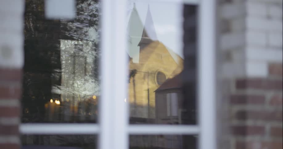 A reflection of a church like building through a paneled window