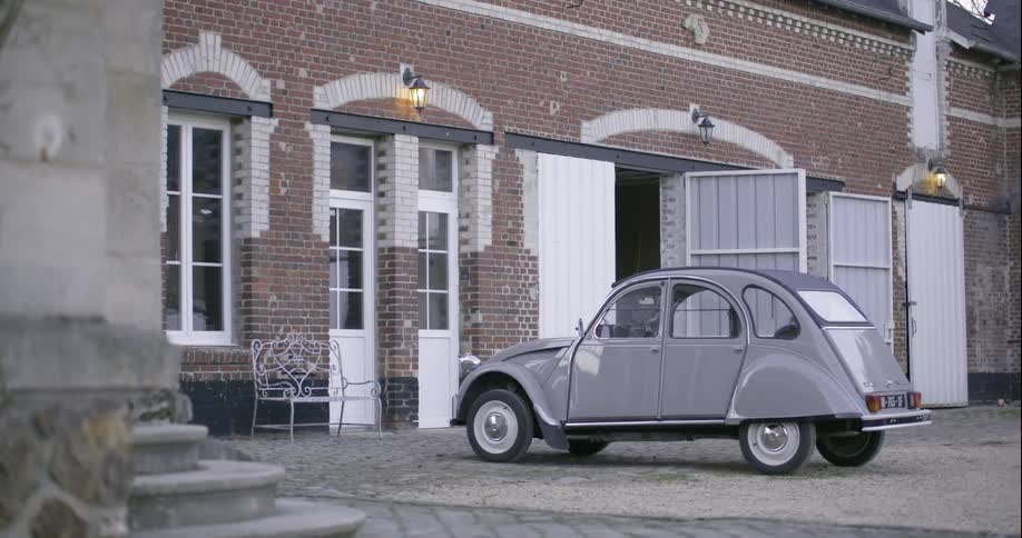 A volkswagen is parked in the courtyard of a brick home