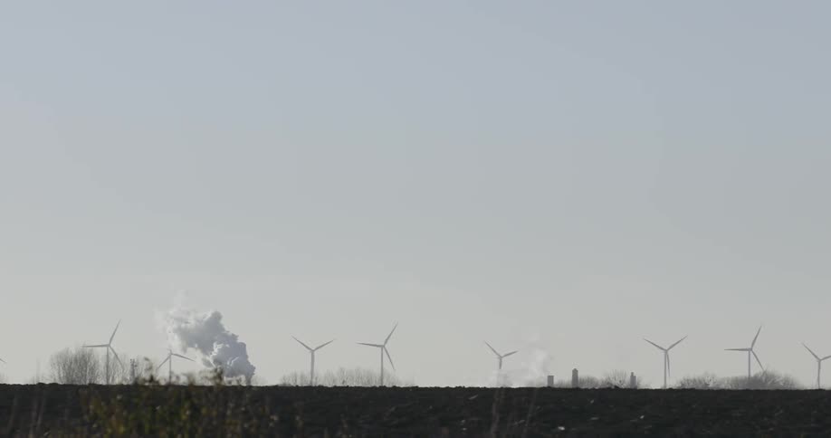 A row of windmills are working in the distance