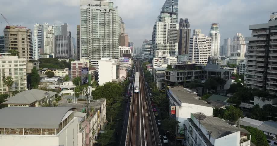 An elevated train travels over the street into the city