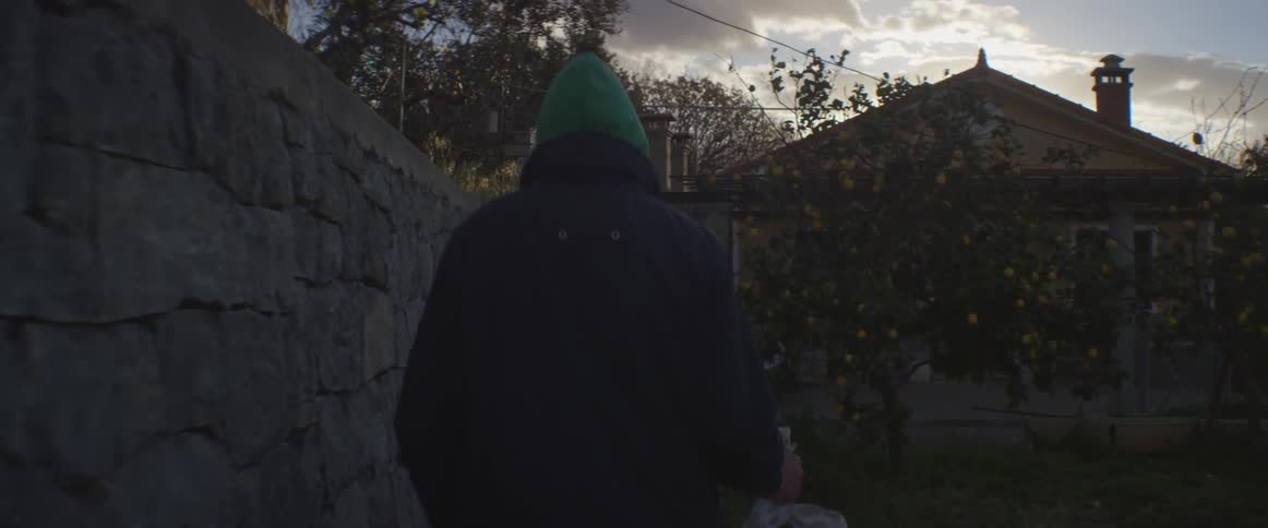 A man carries a bag of trash outside