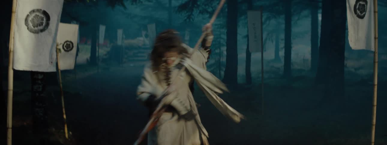 Person with a white outfit and flags around representing a kingdom in a forest