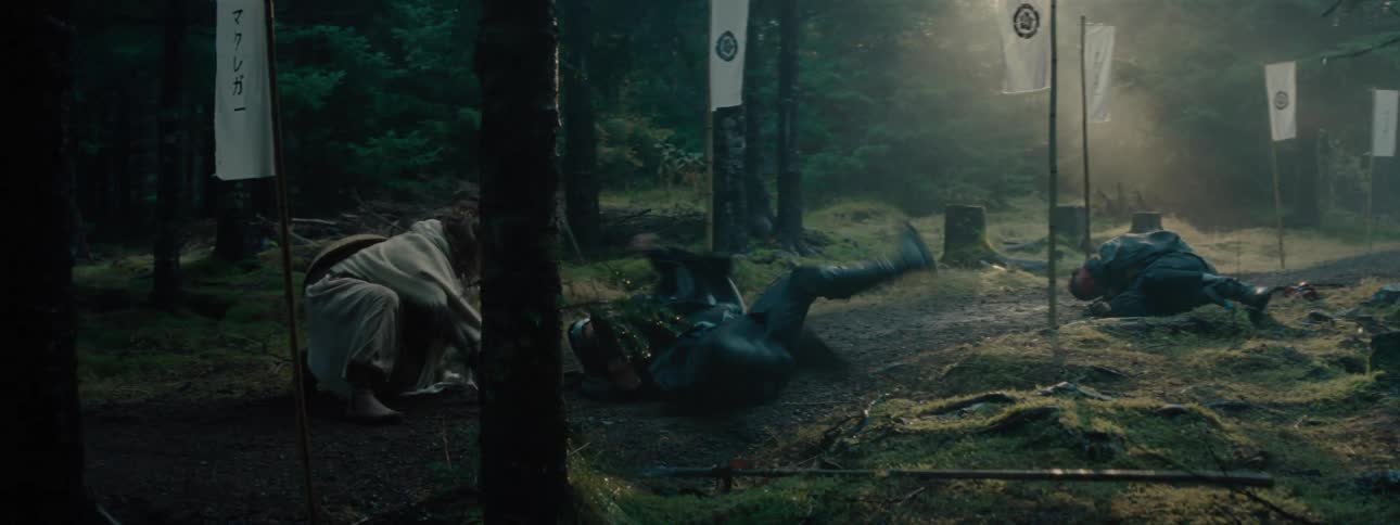 Two warriors in the middle of a forest fighting with one of them falling to the ground