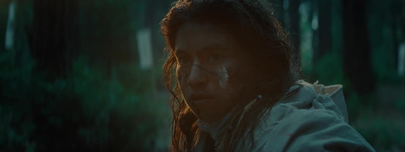 Female warrior stares ahead in the forest