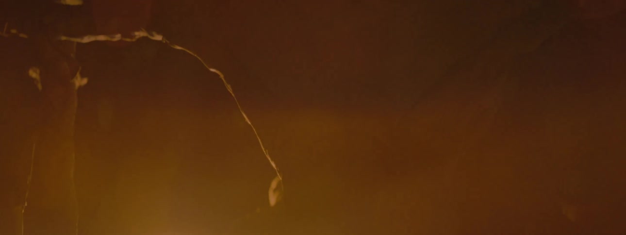 native American scary creature with a mask Some abstract particles spinning in an orange environment that is getting dark
