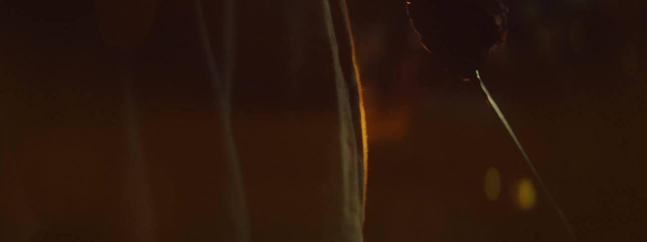 A person walks forward holding a blade