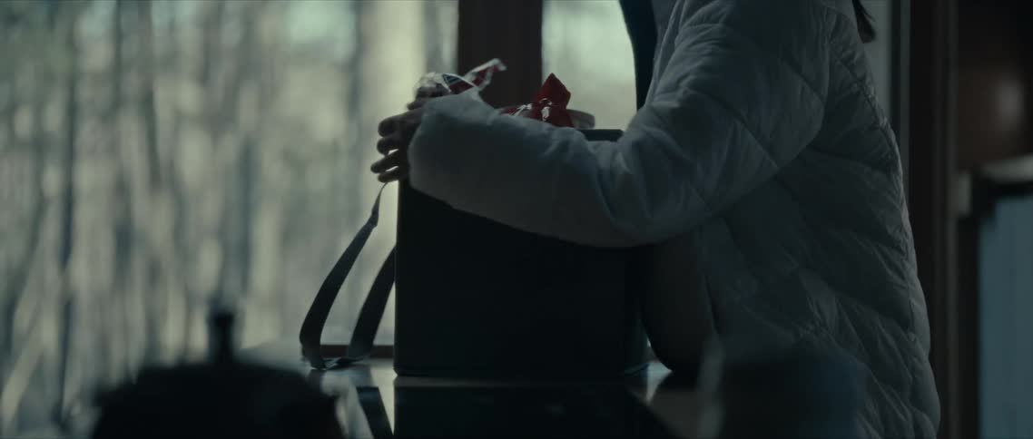 A person places a box with objects on a table and rotates it