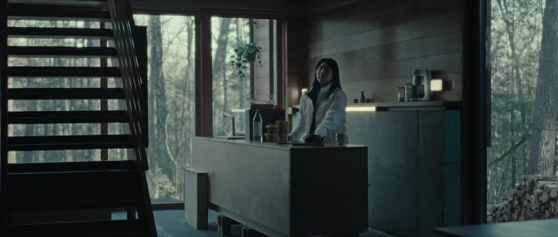 A woman behind a counter in a room with wooden and glass walls