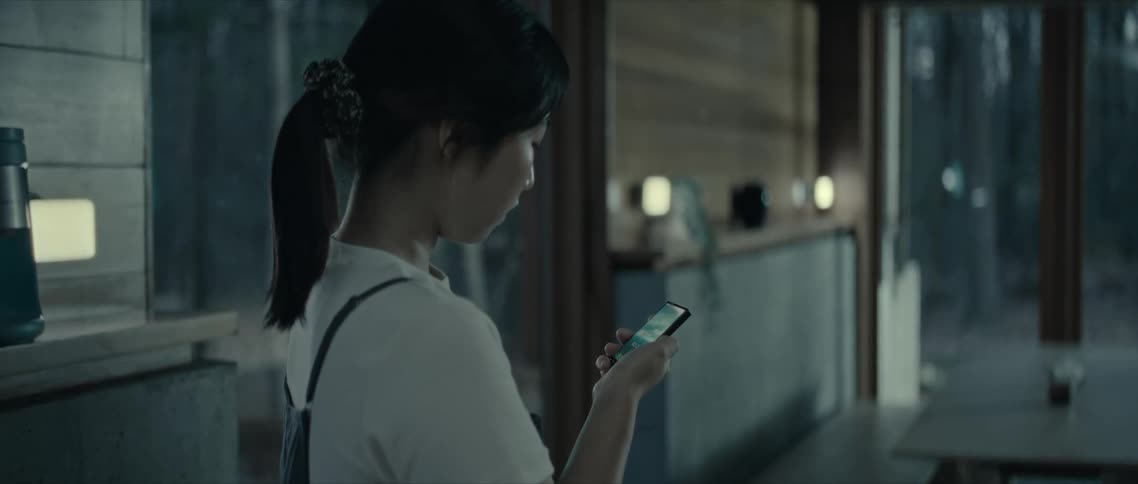 Woman standing in the living room concentrated using a smartphone