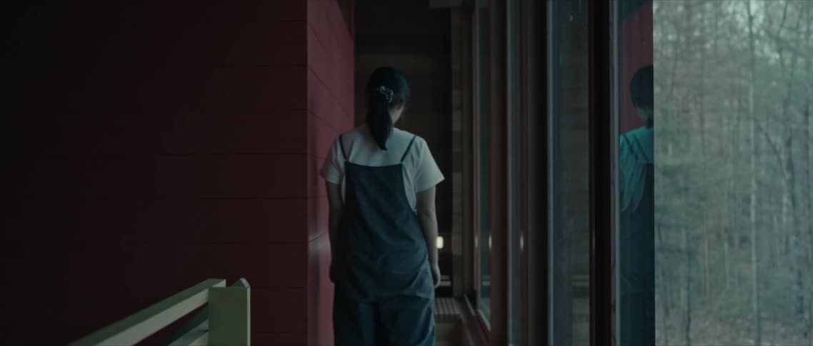 Back view of a woman walking down a hallway of a house