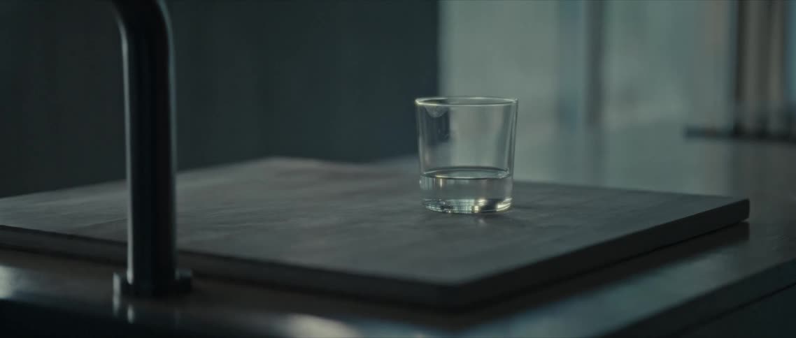 A glass of water over a wooden board in the kitchen countertop