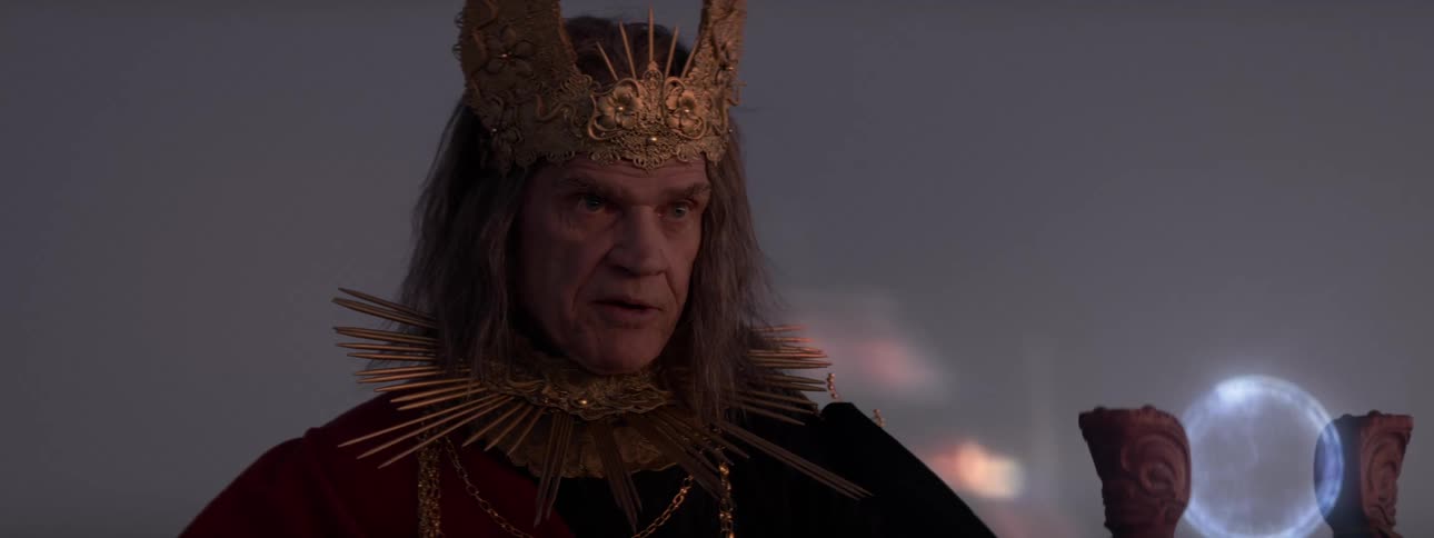 Ruler talks while a scepter holding a glowing orb stands in front of them