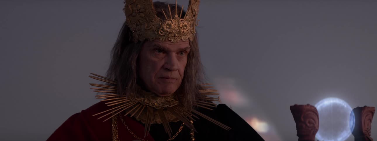 Ruler stares at glowing scepter as an orb rotates between its arms