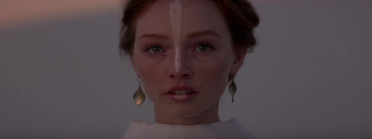 Portrait of a young woman with golden earrings speaking in a desert environment with a blurred background