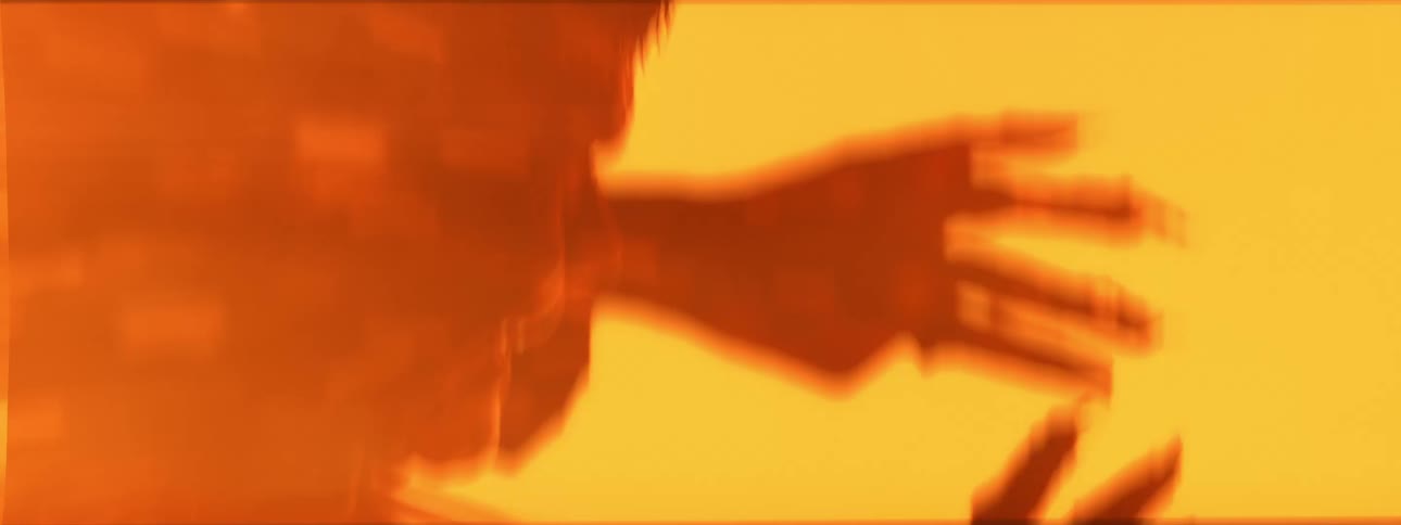 Silhouette of a mans face and hand against an orange vapor