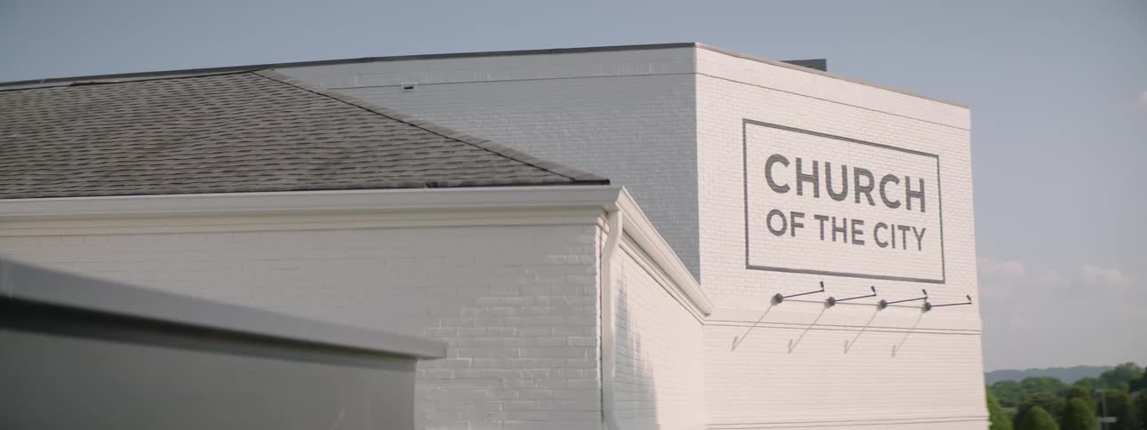 Side of a building with a large sign that says church of the city