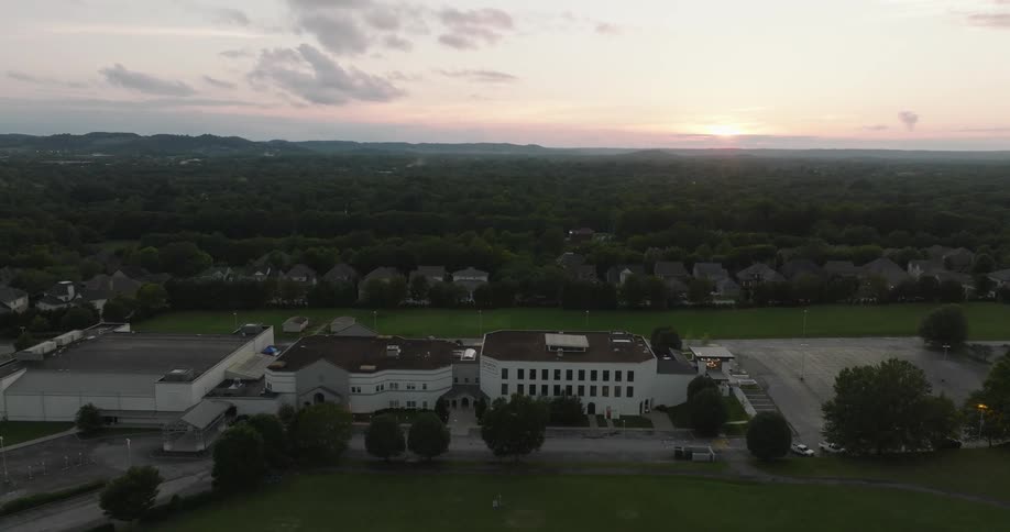 Aerial view of a building complex near a parking lot on a landscape at dusk