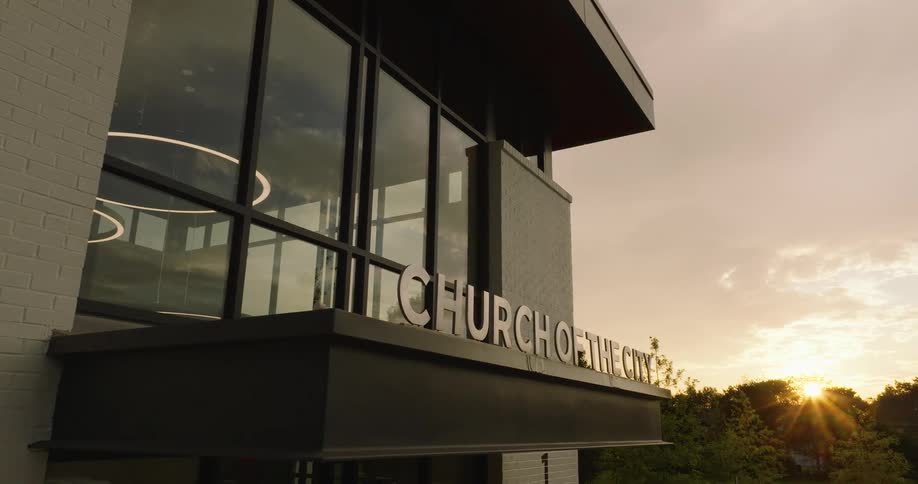 A church with a logo in metal writing on top of its awning