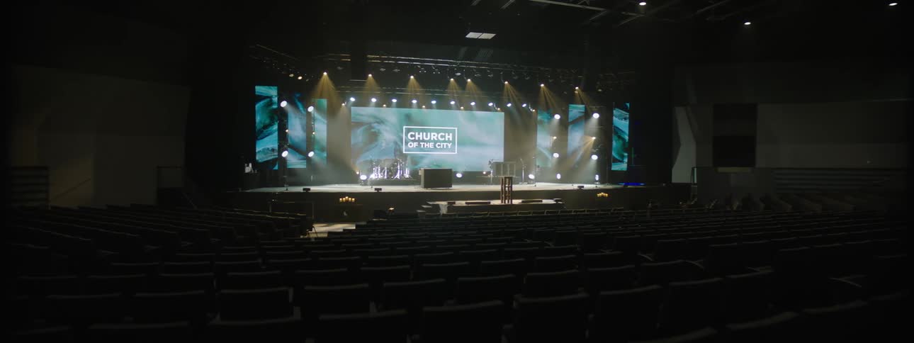 A large church interior with a stage and copious seating