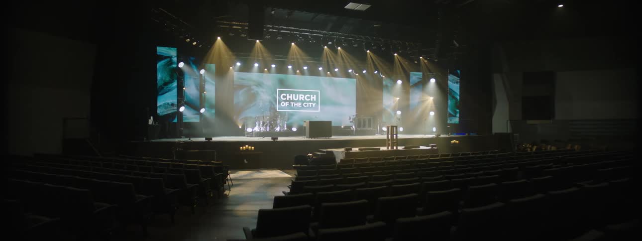 Interior of an auditorium with a lit screen in the background