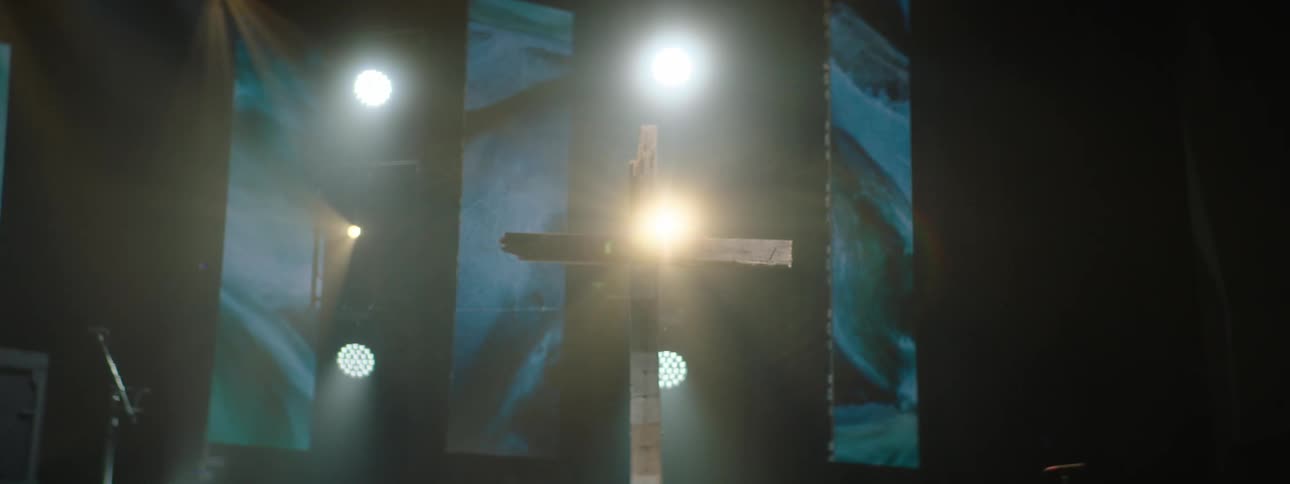 Simple wooden cross under soft light on a stage