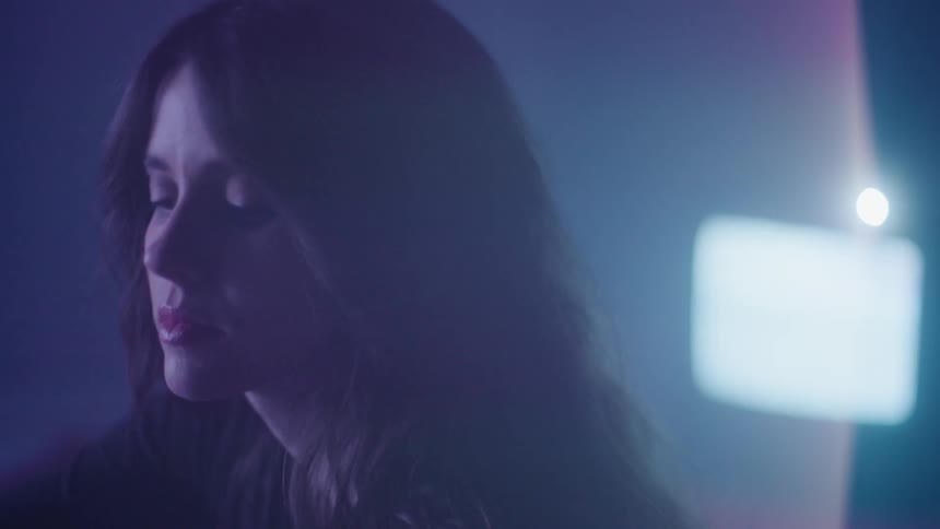 Portrait of a woman in a dark room with light passing through