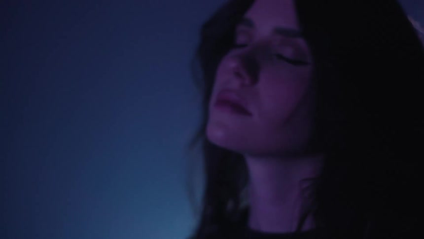 Portrait of a young woman indoors with neon lights around her