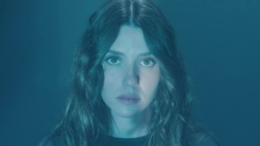 Portrait of a young woman with dark lights passing over her face