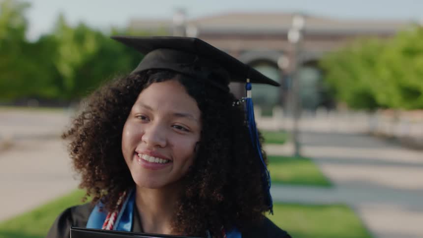 Portrait of a young man and woman wearing a graduation cap and outfit smiling