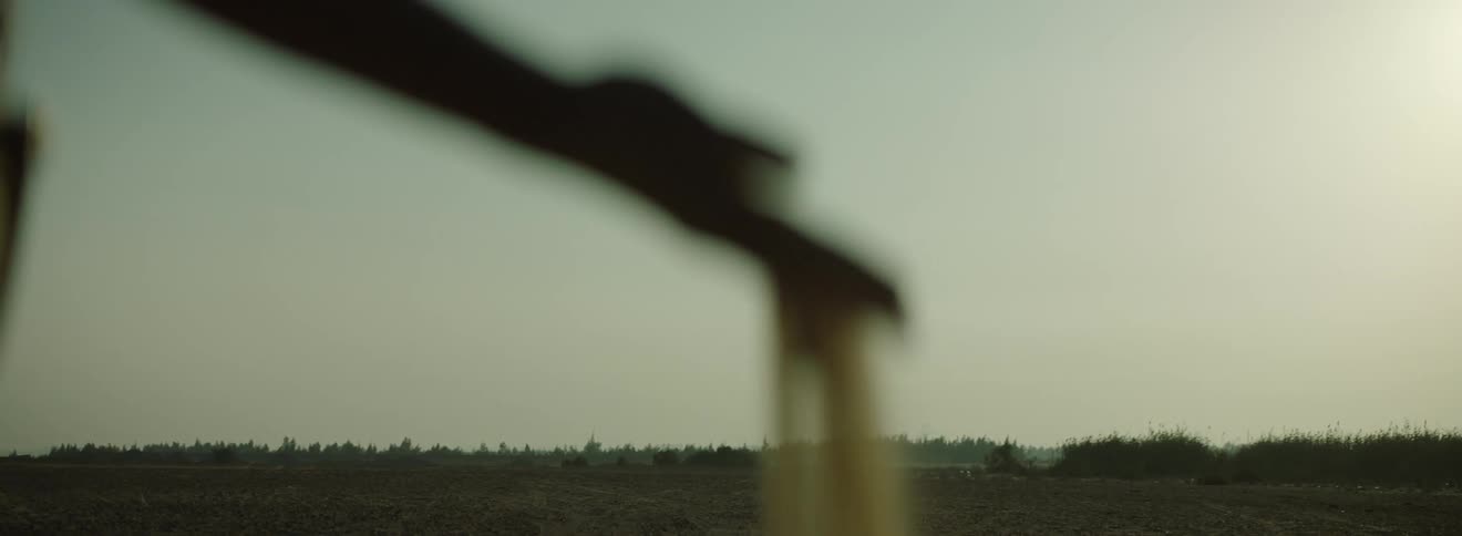 A person drops a handful of sand on a plain
