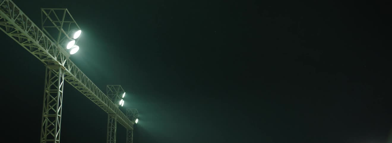 Metal frame holds spotlights high up in the dark sky