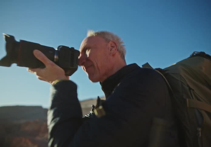 Man photographing with a professional camera in a desert and mountainous environment