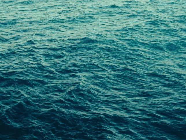 The sea water moving in small ripples and with a dark blue