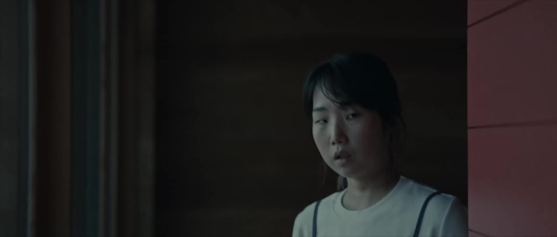 Young woman walking in a corner of the house with facial expression of fear