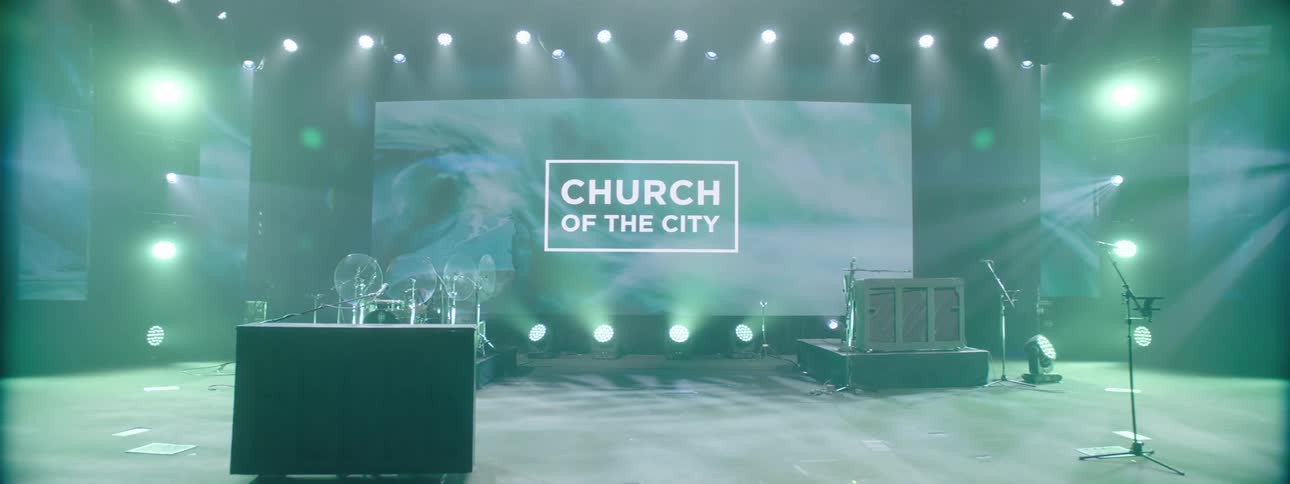 A stage set up with musical instruments and equipment including microphones a drum set and guitars