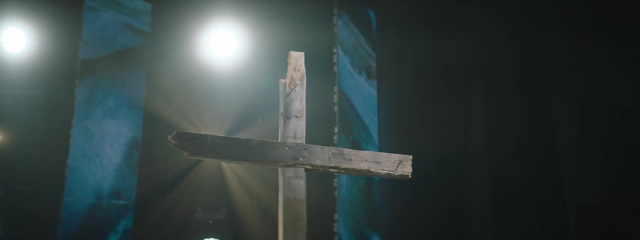 Illuminated wooden cross inside an auditorium