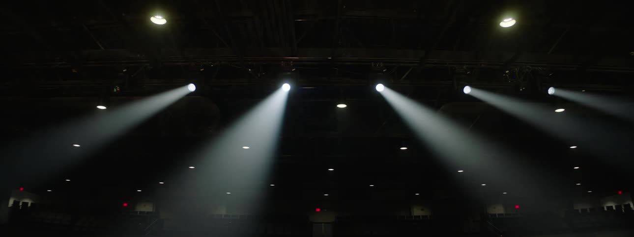 Multiple spotlights shining a white light on an empty stage