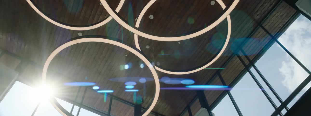 A modern interior with circular light fixtures hanging from the ceiling and large windows