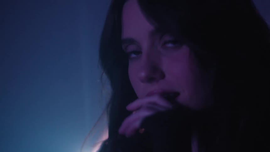 Portrait of a young woman indoors with neon lights around her