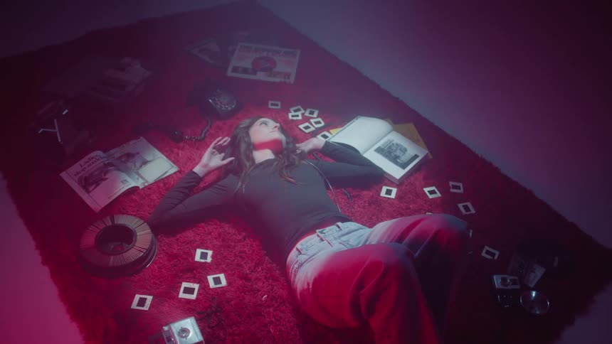 Woman lying on a red carpet with books in pictures around her