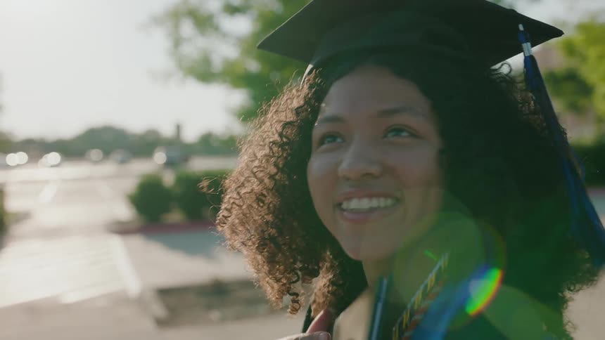 Close up of a young wearing a graduation cap is happy