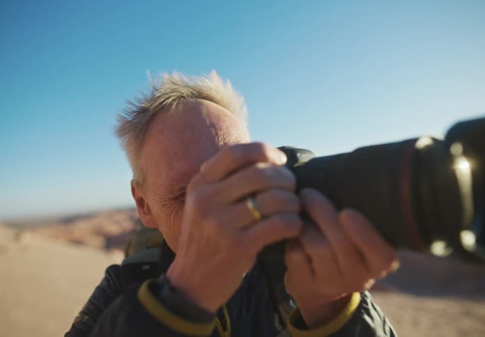 Photographer taking pictures with the wind blowing through his hair