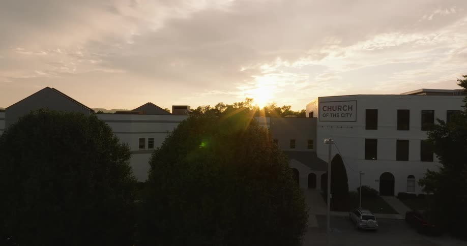 Aerial panorama of the facade of a church building with the sunset on the horizon