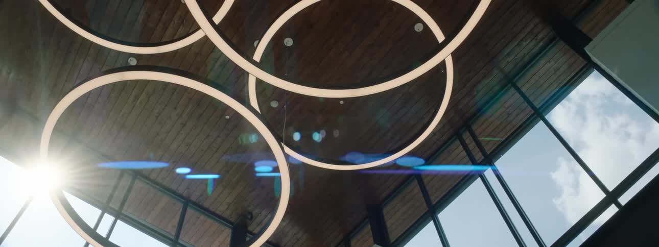 A building interior has a series of rings suspended from the ceiling