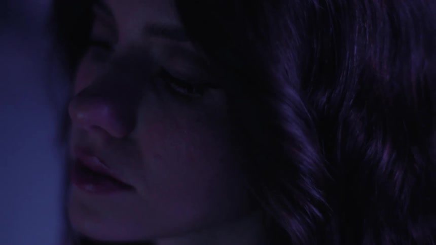 A young woman blinks as a light washes over her face