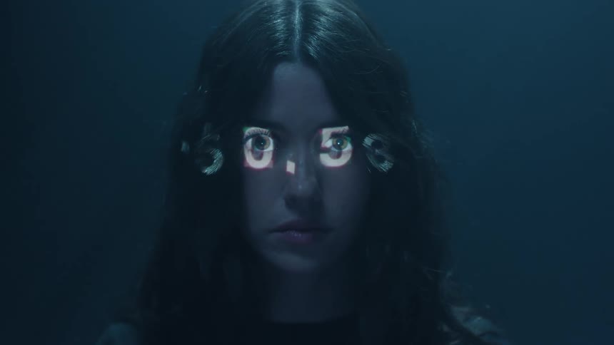 A series of numbers flashes across the face of a young woman