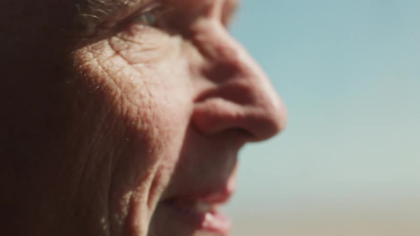 Side portrait of an elderly man inside a moving car