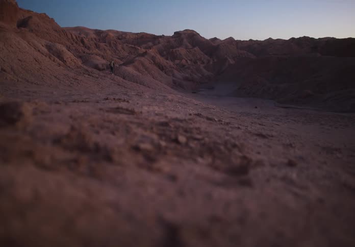 Rugged terrain with rolling hills under a twilight sky